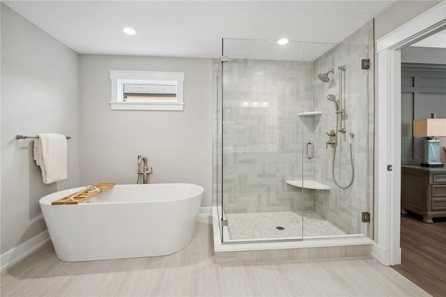 9660 Goehring Rd, Cranberry Twp, PA 16066 - full bath with a stall shower, a freestanding tub, baseboards, recessed lighting, and wood finished floors