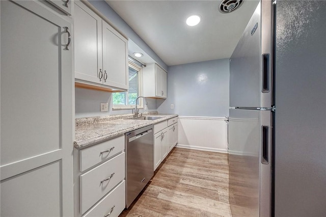 111 York Way, Center Twp Bea, PA 15061 - kitchen featuring stainless steel appliances, a sink, light wood finished floors, wainscoting, and white cabinetry