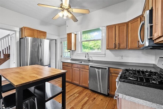 3565 Gerber Ave, Brighton Heights, PA 15212 - kitchen featuring appliances with stainless steel finishes, a sink, a ceiling fan, light wood-style flooring, and brown cabinetry