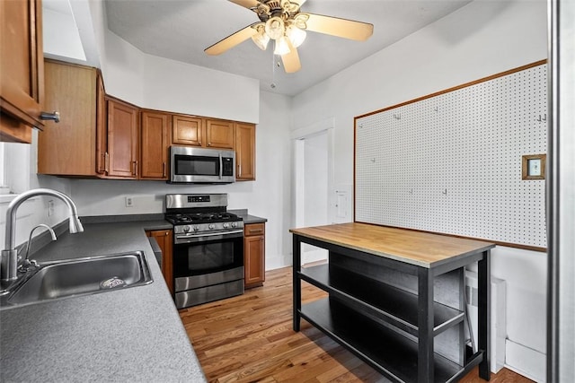 3565 Gerber Ave, Brighton Heights, PA 15212 - kitchen with stainless steel appliances, a sink, brown cabinets, light wood finished floors, and ceiling fan