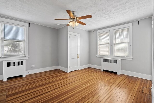 3565 Gerber Ave, Brighton Heights, PA 15212 - empty room with radiator heating unit, light wood-style flooring, baseboards, a ceiling fan, and a textured ceiling