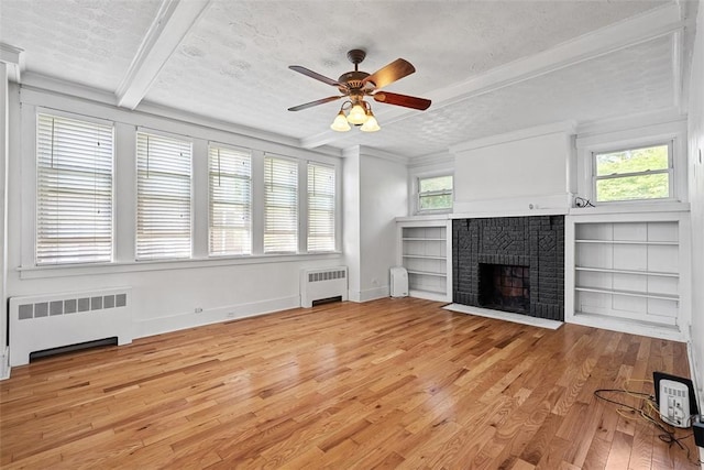 3565 Gerber Ave, Brighton Heights, PA 15212 - unfurnished living room with radiator heating unit, light wood-type flooring, a fireplace, healthy amount of natural light, and a textured ceiling