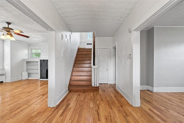 3565 Gerber Ave, Brighton Heights, PA 15212 - stairway with a fireplace, baseboards, radiator, wood finished floors, and a textured ceiling