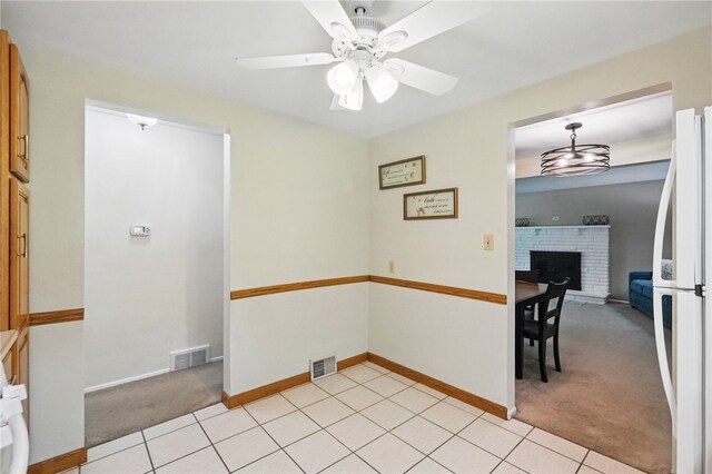 652 Westland Dr, Richland, PA 15044 - unfurnished dining area with light colored carpet, a fireplace with raised hearth, a ceiling fan, baseboards, and light tile patterned floors