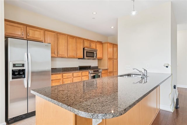 5570 Centre Ave Unit 306, Shadyside, PA 15232 - kitchen featuring stainless steel appliances, dark stone counters, a peninsula, recessed lighting, and wood finished floors