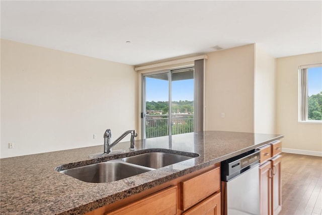 5570 Centre Ave Unit 306, Shadyside, PA 15232 - kitchen featuring stainless steel dishwasher, dark stone countertops, light wood-style flooring, and brown cabinets