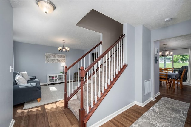 132 Naughton Cir, Forward Twp But, PA 16033 - stairs with a chandelier, wood finished floors, baseboards, and a textured ceiling