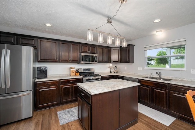 132 Naughton Cir, Forward Twp But, PA 16033 - kitchen with stainless steel appliances, a sink, a kitchen island, wood finished floors, and dark brown cabinetry