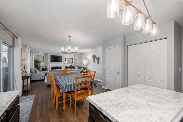 132 Naughton Cir, Forward Twp But, PA 16033 - dining space featuring a chandelier, a fireplace, dark wood-style flooring, a textured ceiling, and baseboards