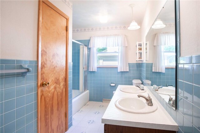 3460 Ridgewood Dr, Hermitage, PA 16148 - bathroom featuring tile walls, plenty of natural light, double vanity, wainscoting, and shower / bath combination with glass door