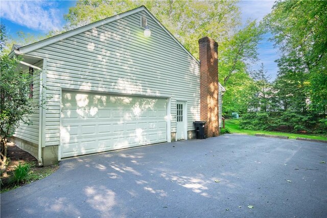 3460 Ridgewood Dr, Hermitage, PA 16148 - view of side of home featuring a garage and a chimney