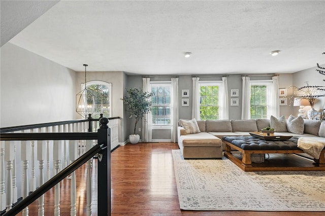 901 Montclair Dr, Moon/Crescent Twp, PA 15108 - living room featuring wood finished floors, a chandelier, baseboards, and a textured ceiling