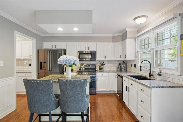 901 Montclair Dr, Moon/Crescent Twp, PA 15108 - kitchen with stainless steel appliances, a sink, dark wood finished floors, crown molding, and light stone counters