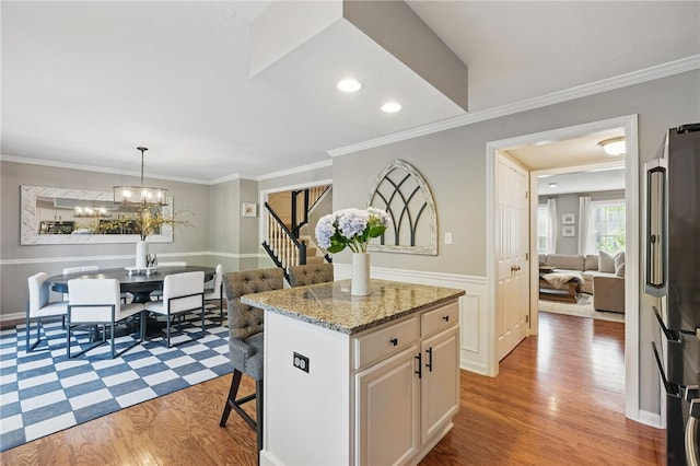 901 Montclair Dr, Moon/Crescent Twp, PA 15108 - kitchen with freestanding refrigerator, light wood-type flooring, crown molding, a center island, and a kitchen bar