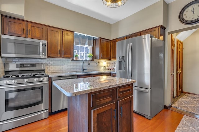 1201 Carlisle St, Natrona Hts/Harrison Twp, PA 15065 - kitchen with appliances with stainless steel finishes, a sink, light wood-type flooring, and decorative backsplash