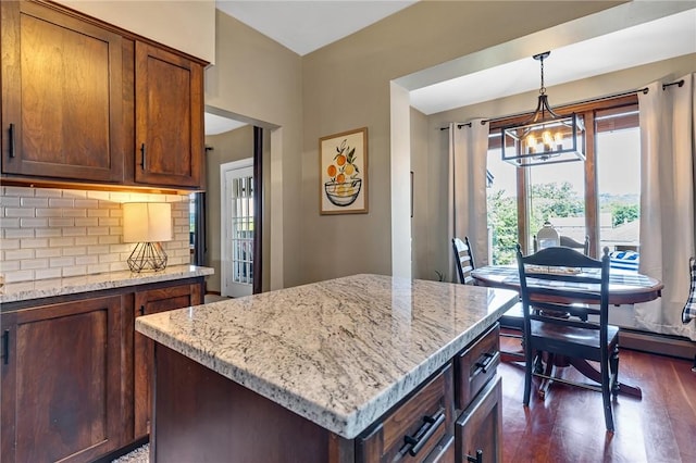 1201 Carlisle St, Natrona Hts/Harrison Twp, PA 15065 - kitchen featuring dark wood-style floors, a chandelier, light stone countertops, backsplash, and decorative light fixtures