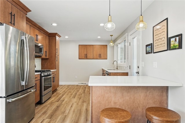 118 Eakin Ave, Ross Twp, PA 15214 - kitchen featuring appliances with stainless steel finishes, brown cabinetry, a sink, light wood finished floors, and recessed lighting
