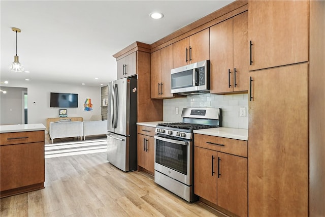 118 Eakin Ave, Ross Twp, PA 15214 - kitchen featuring appliances with stainless steel finishes, light countertops, brown cabinets, light wood finished floors, and decorative backsplash
