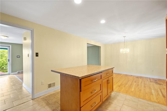 1064 Glen Oak Dr, Bethel Park, PA 15102 - kitchen with a chandelier, a center island, pendant lighting, light tile patterned flooring, and baseboards