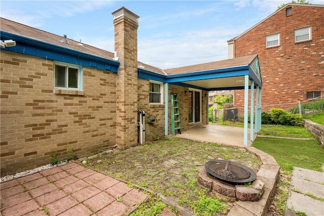 1064 Glen Oak Dr, Bethel Park, PA 15102 - back of house featuring a patio, an outdoor fire pit, a chimney, and brick siding