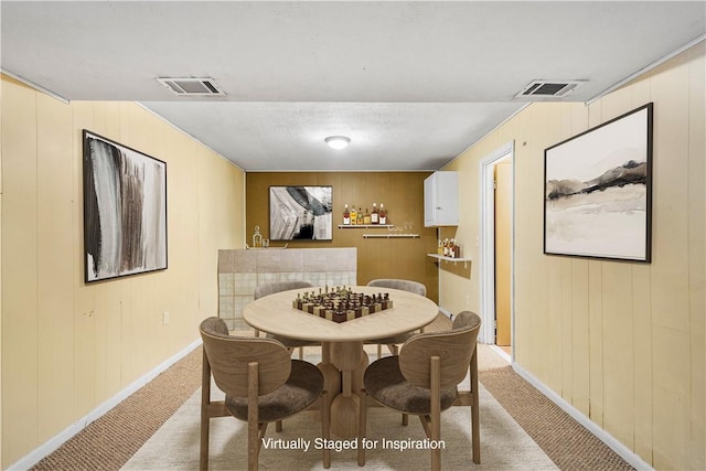 1064 Glen Oak Dr, Bethel Park, PA 15102 - dining room featuring light colored carpet, baseboards, and wood walls