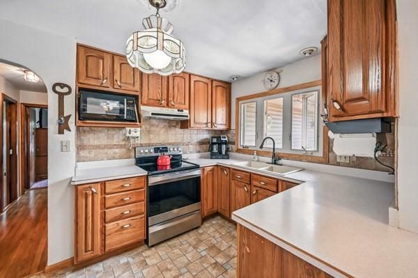 260 S Oakdale Ave, Hermitage, PA 16148 - kitchen with stainless steel electric stove, black microwave, a sink, arched walkways, and under cabinet range hood
