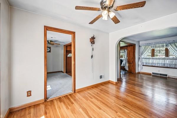 260 S Oakdale Ave, Hermitage, PA 16148 - spare room featuring arched walkways, wood finished floors, ceiling fan, and baseboards