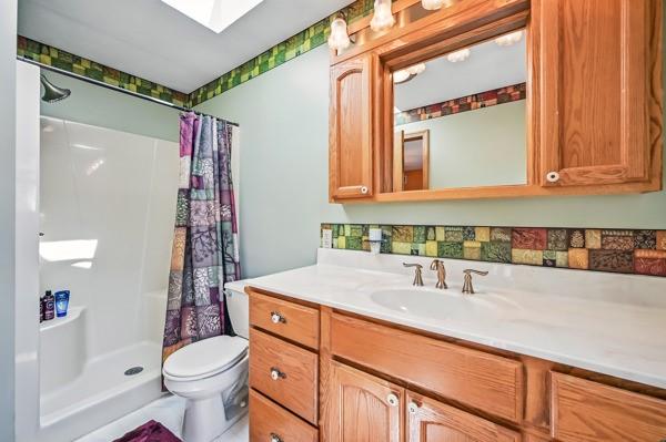 260 S Oakdale Ave, Hermitage, PA 16148 - full bath with toilet, vanity, a shower with shower curtain, and a skylight