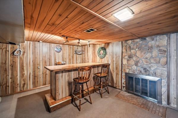 260 S Oakdale Ave, Hermitage, PA 16148 - indoor dry bar featuring wooden walls, wooden ceiling, a stone fireplace, and carpet floors
