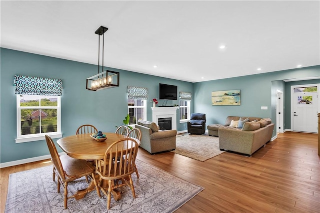121 Derby Ln, North Fayette, PA 15071 - dining space with a glass covered fireplace, wood finished floors, recessed lighting, baseboards, and a chandelier