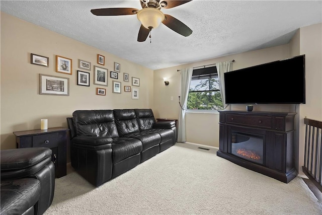 119 Summit Ridge Dr, Bridgeville, PA 15017 - living area with carpet, a textured ceiling, a glass covered fireplace, ceiling fan, and baseboards