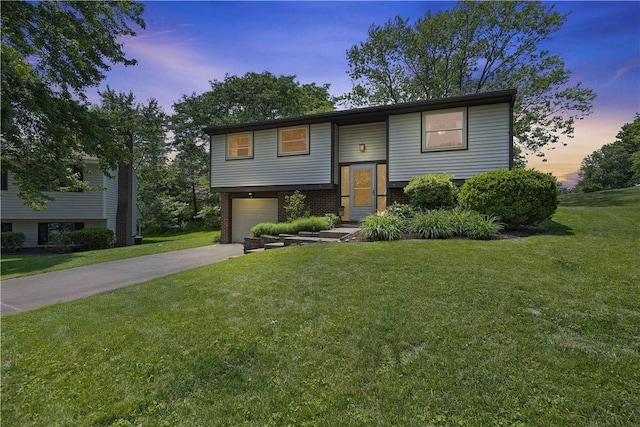 119 Summit Ridge Dr, Bridgeville, PA 15017 - bi-level home with driveway, an attached garage, a lawn, and brick siding