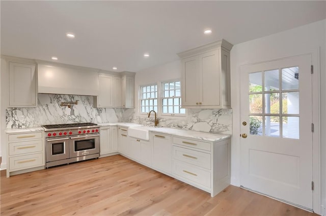 129 S Dr, Fox Chapel, PA 15238 - kitchen with range with two ovens, a sink, backsplash, light wood-style flooring, and recessed lighting
