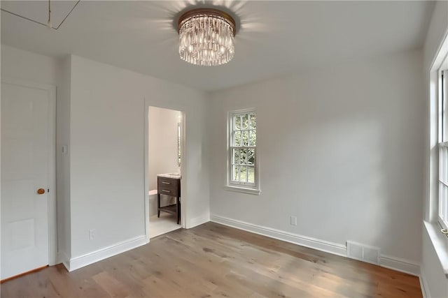 129 S Dr, Fox Chapel, PA 15238 - unfurnished bedroom with a chandelier, wood finished floors, baseboards, and ensuite bathroom