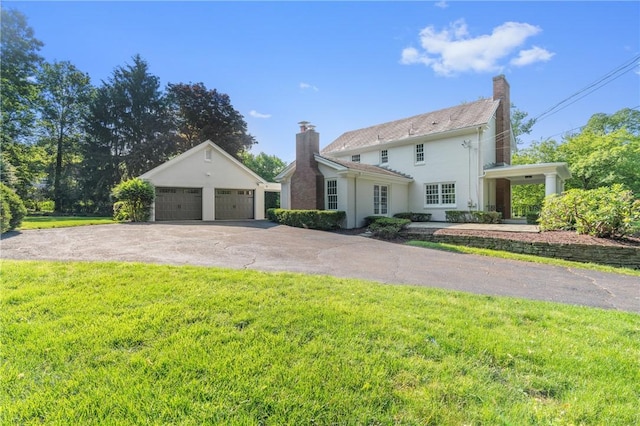 129 S Dr, Fox Chapel, PA 15238 - view of front of property with a chimney, a garage, a front yard, and stucco siding