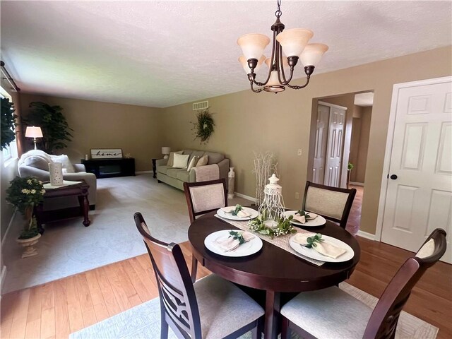 138 Willow Run Dr, Center Twp But, PA 16001 - dining room featuring a chandelier, light wood finished floors, a textured ceiling, and baseboards