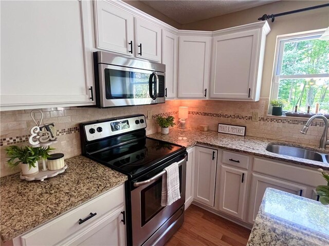 138 Willow Run Dr, Center Twp But, PA 16001 - kitchen featuring stainless steel appliances, a sink, white cabinetry, backsplash, and wood finished floors