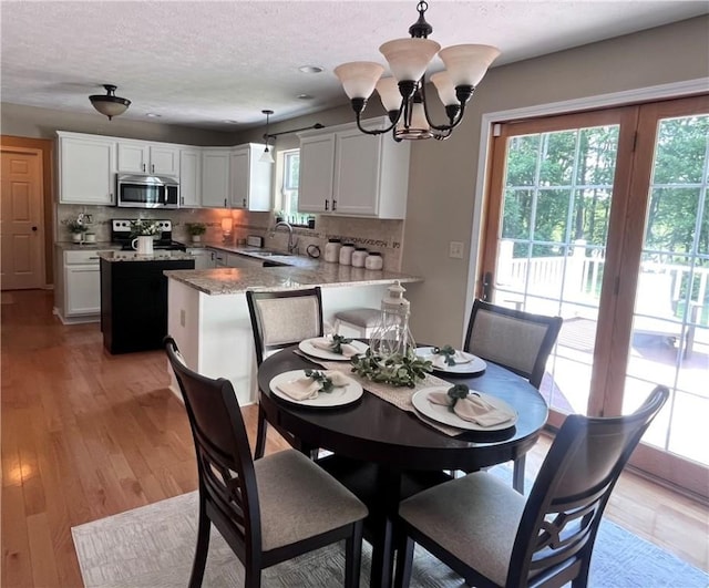 138 Willow Run Dr, Center Twp But, PA 16001 - dining room with a chandelier, light wood-type flooring, and a textured ceiling