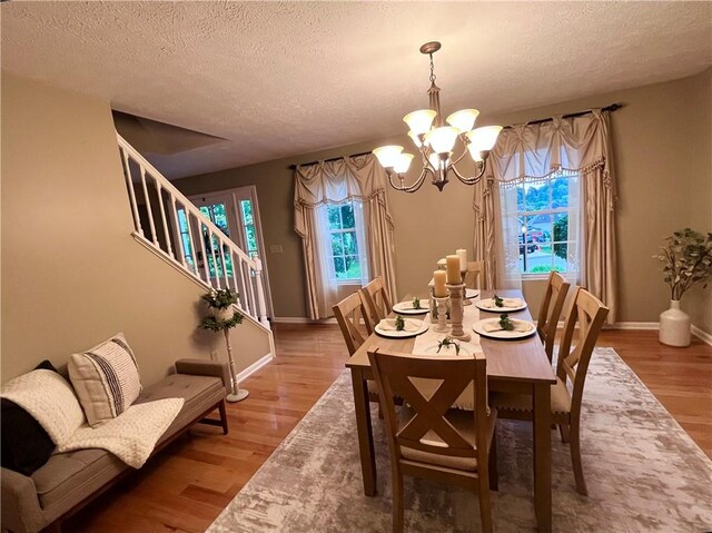 138 Willow Run Dr, Center Twp But, PA 16001 - dining space featuring a chandelier, a textured ceiling, plenty of natural light, wood finished floors, and stairs
