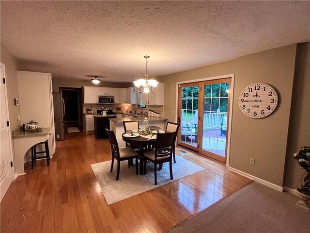 138 Willow Run Dr, Center Twp But, PA 16001 - dining room with hardwood / wood-style floors, a chandelier, a textured ceiling, and baseboards
