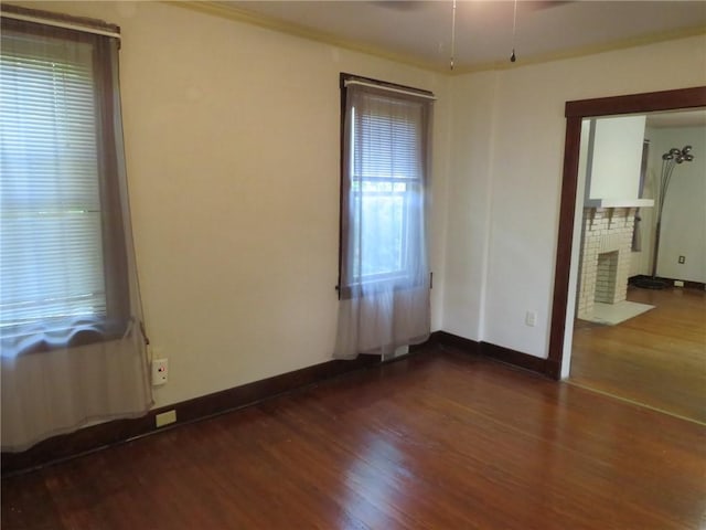1111 Progress St, Mckees Rocks, PA 15136 - empty room featuring dark wood-style floors, a brick fireplace, and baseboards