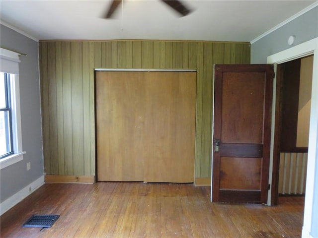 1111 Progress St, Mckees Rocks, PA 15136 - unfurnished bedroom with hardwood / wood-style flooring, a closet, ornamental molding, wood walls, and baseboards