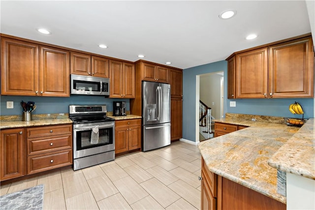 227 Shady Knoll Dr, Scott Twp Sal, PA 15220 - kitchen with stainless steel appliances, brown cabinetry, recessed lighting, light stone countertops, and a peninsula
