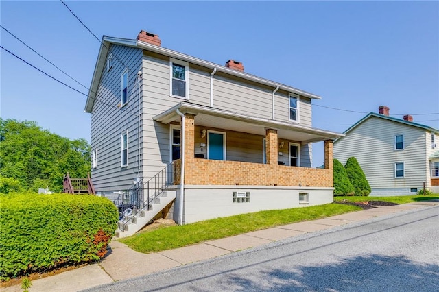 149-151 French St, Hempfield Twp Wml, PA 15601 - view of front facade with a chimney, covered porch, and brick siding