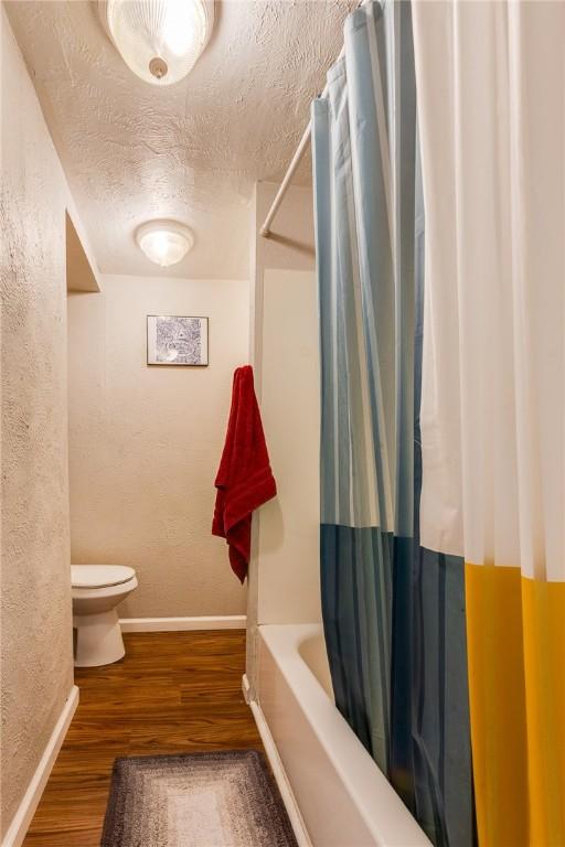 149-151 French St, Hempfield Twp Wml, PA 15601 - full bathroom featuring toilet, wood finished floors, baseboards, a textured ceiling, and shower / bath combination with curtain
