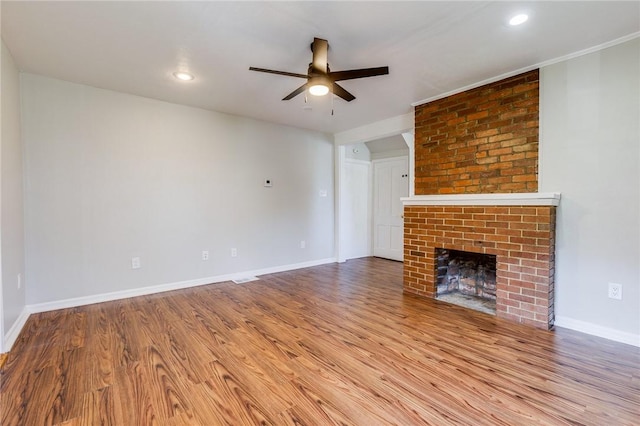 149-151 French St, Hempfield Twp Wml, PA 15601 - unfurnished living room featuring ceiling fan, wood finished floors, a brick fireplace, baseboards, and recessed lighting