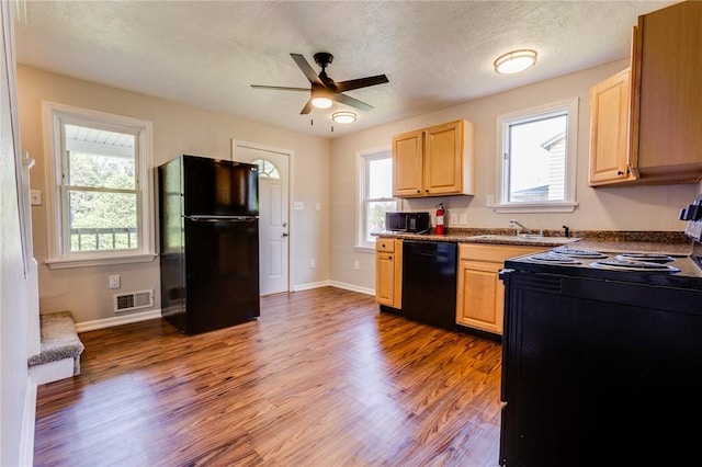 149-151 French St, Hempfield Twp Wml, PA 15601 - kitchen with black appliances, light brown cabinetry, a sink, and dark wood-style flooring