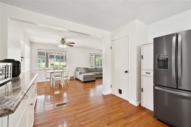 3702 School Rd, Murrysville, PA 15668 - kitchen featuring stainless steel appliances, white cabinets, light wood-style floors, ceiling fan, and stone counters