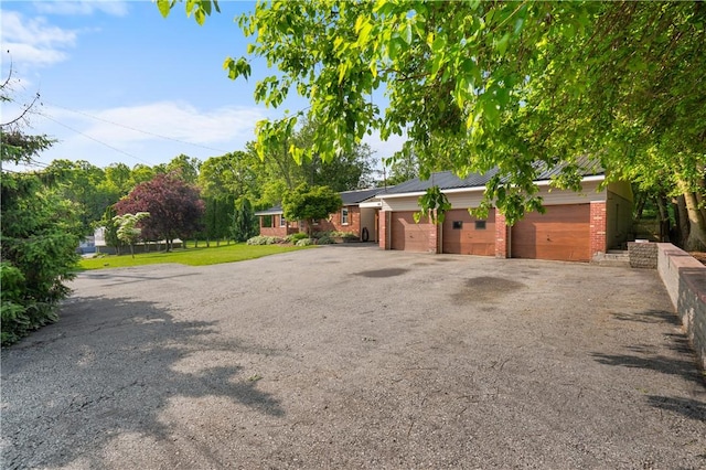 988 Croft Rd, Salem Twp Wml, PA 15601 - view of property exterior featuring driveway, brick siding, an attached garage, and metal roof