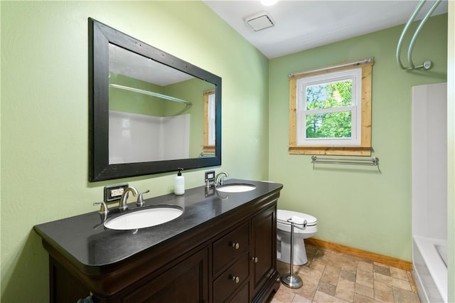 988 Croft Rd, Salem Twp Wml, PA 15601 - full bath featuring toilet, double vanity, stone finish flooring, bathing tub / shower combination, and baseboards